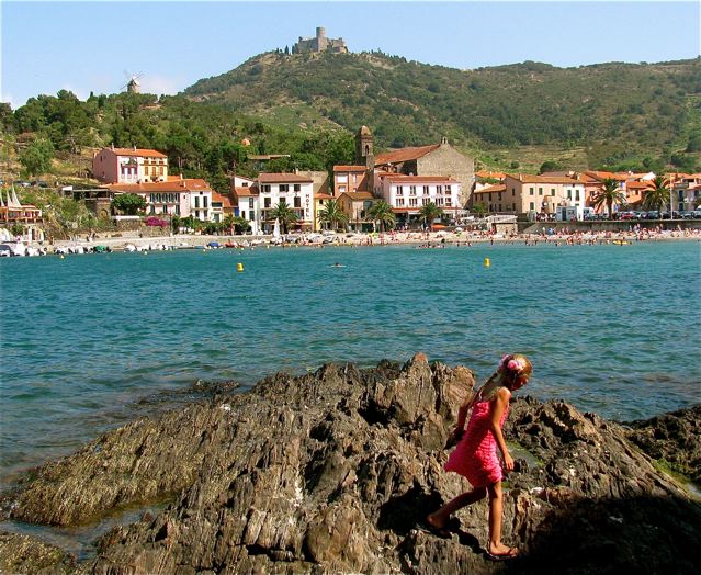 Family travel in France girl on rocks on Vermeille Coast in Collioure Family travel in France girl on rocks on Vermeille Coast in Collioure