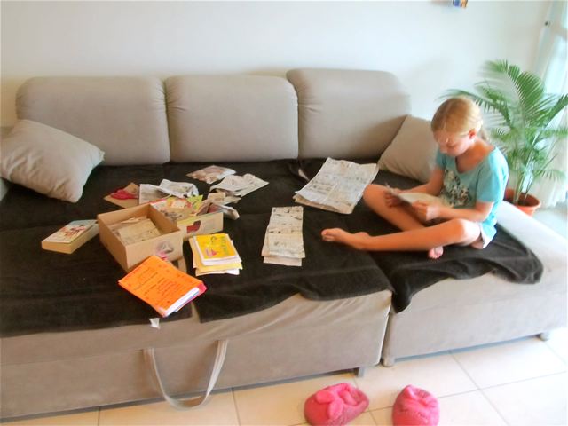 Our international student reading letters, cards, comics and care packages from home happily Our international student reading letters, cards, comics and care packages from home happily