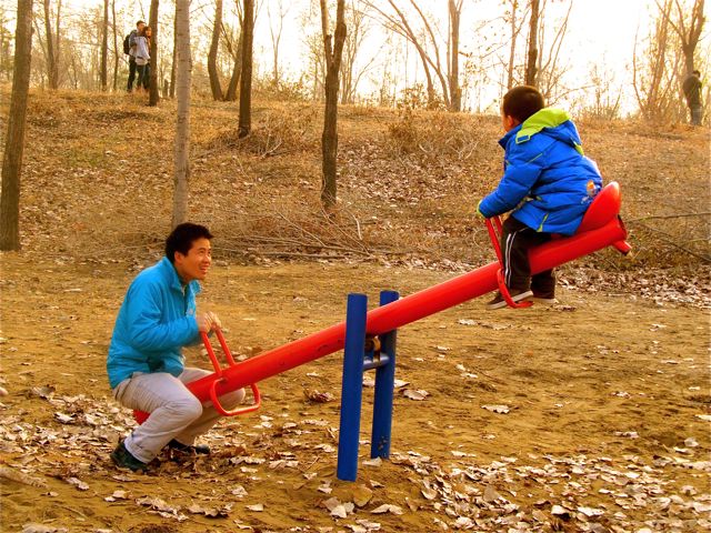 Playing in a Beijing park, Andrew and his dad on seesaw Playing in a Beijing park, Andrew and his dad on seesaw