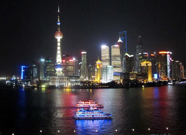dazzling Shanghai skyline from Bund, futuristic architecture, boats and lights dazzling Shanghai skyline from Bund, futuristic architecture, boats and lights