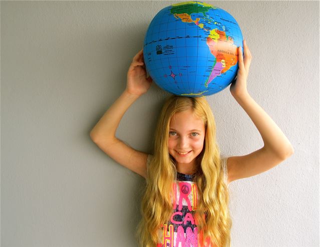 Cute young girl who is world's most traveled kid with the world in her hands Cute young girl who is world's most traveled kid with the world in her hands