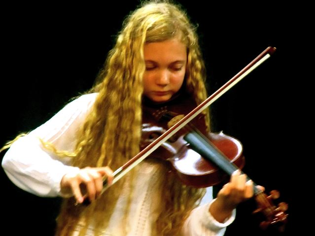 Musical travel teen Mozart playing violin at a performance in Asia