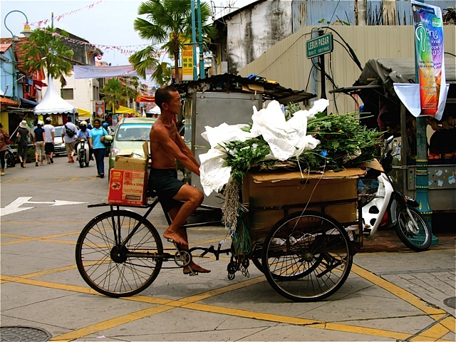 Barefoot Chinese man on loaded rickshaw Barefoot Chinese man on loaded rickshaw